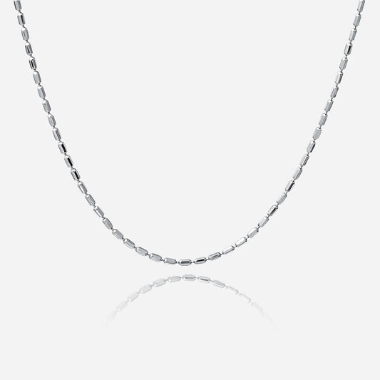 Silver chain necklace on a light gray background