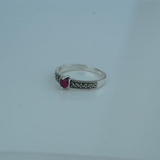 Silver ring with a  gemstone on a light gray background