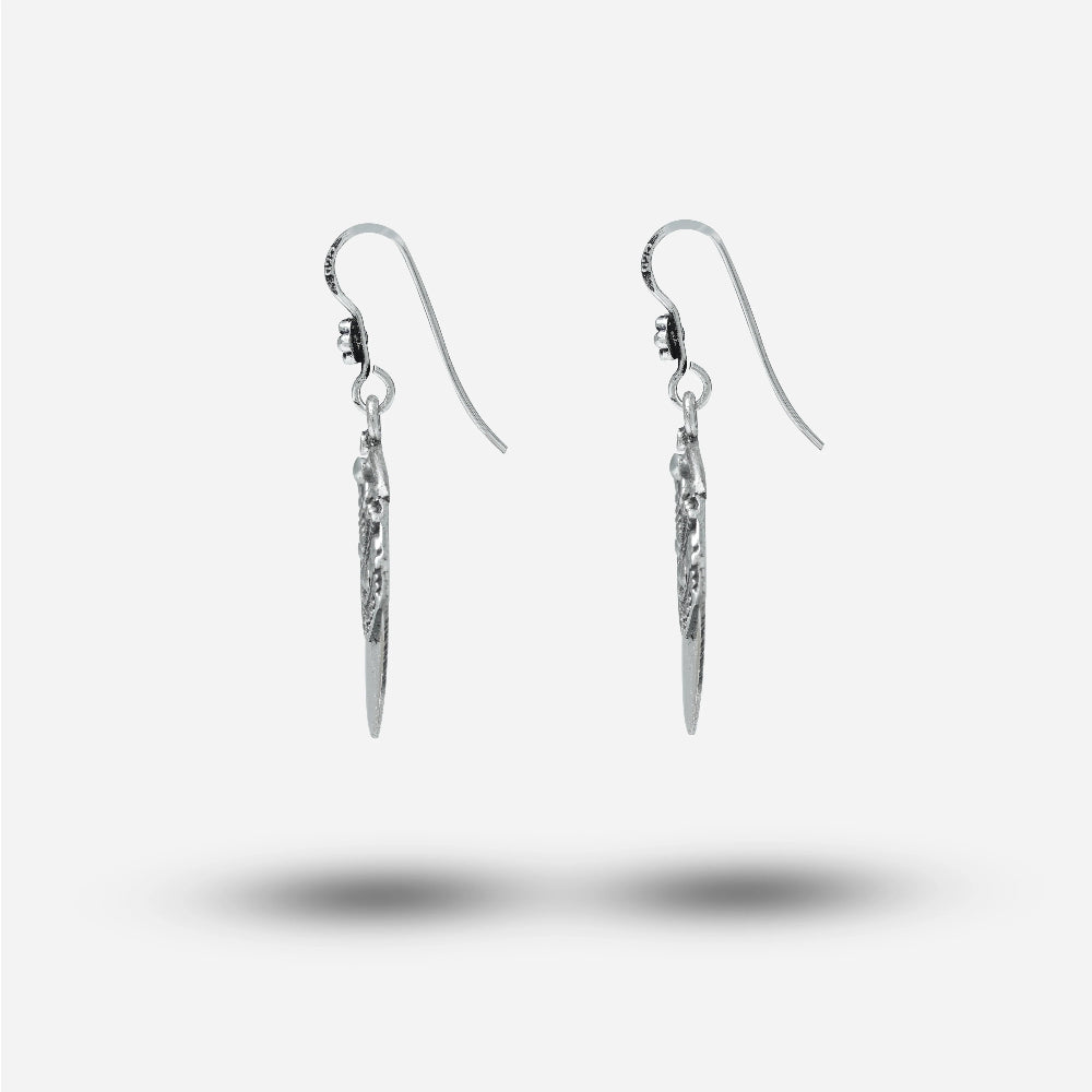 Pair of silver vintage earrings on a light gray background