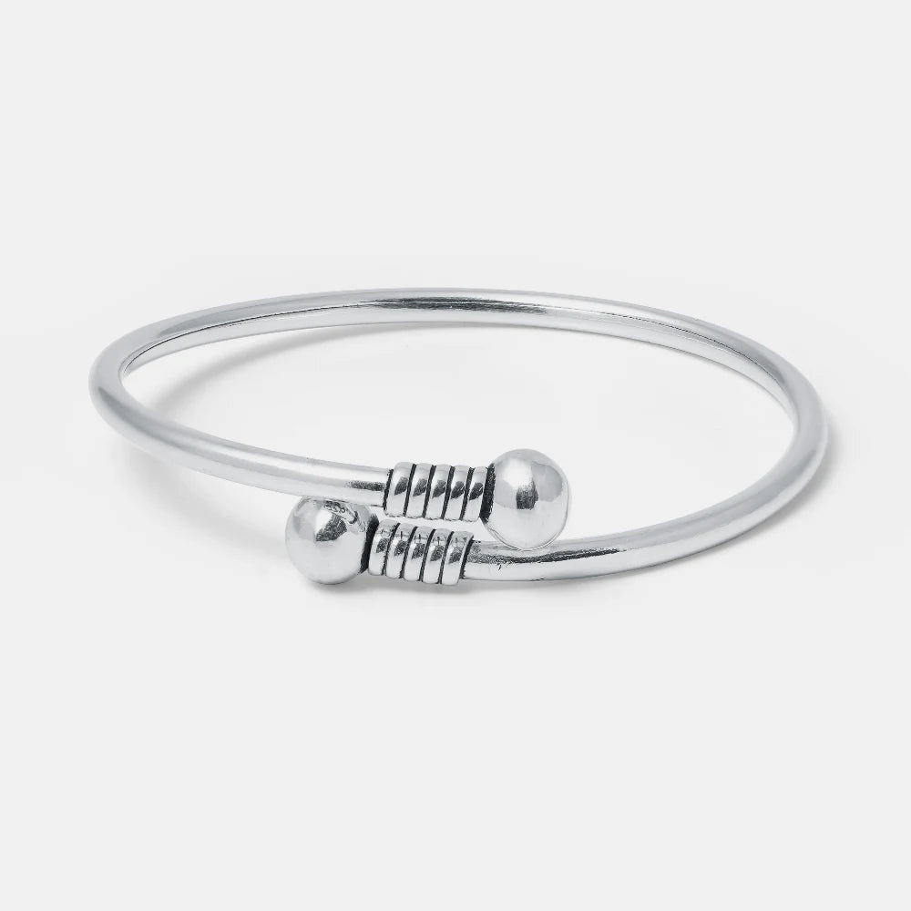 Silver bangle with a clasp on a light gray background