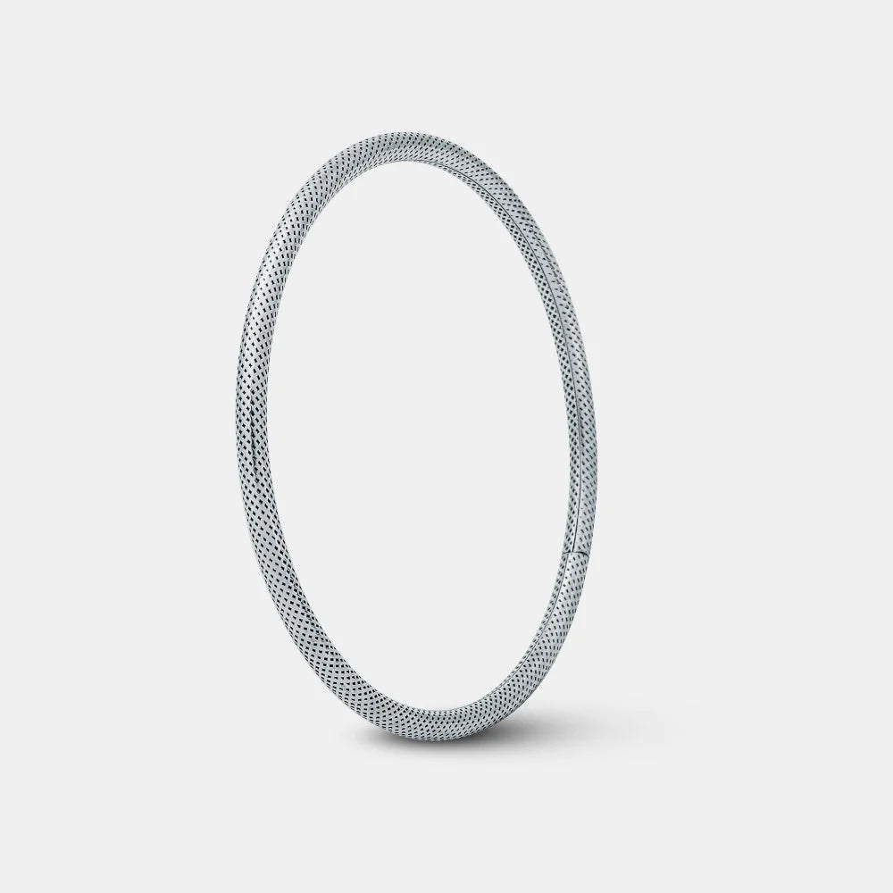 Silver bangle on a light gray background