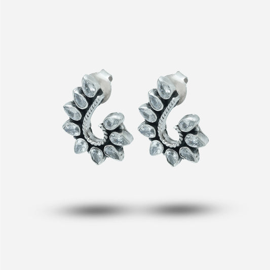 Pair of silver traditional earrings with clear gemstones on a light gray background