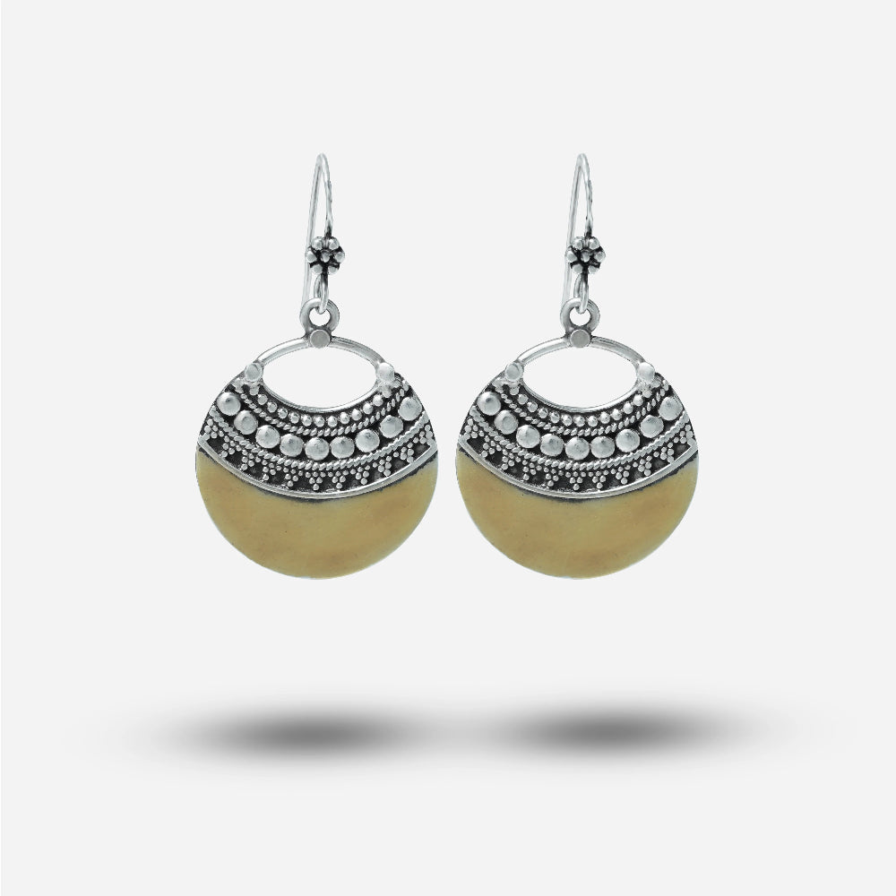 Pair of vintage earrings with silver and beige design on a white background