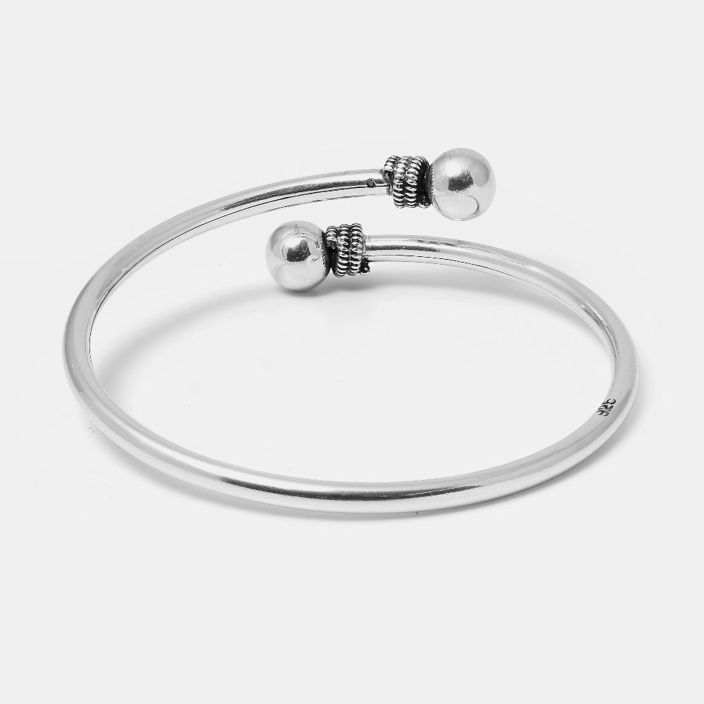 Silver bracelet with spherical beads on a light gray background