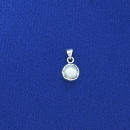 Silver pendant with a white stone on a blue background