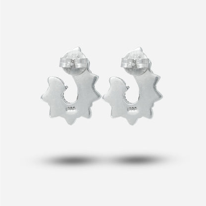 Silver traditional earrings with a star-like design on a light gray background