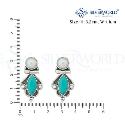 Pair of earrings with turquoise stones and pearl-like centers, shown with a ruler for scale on a white background.