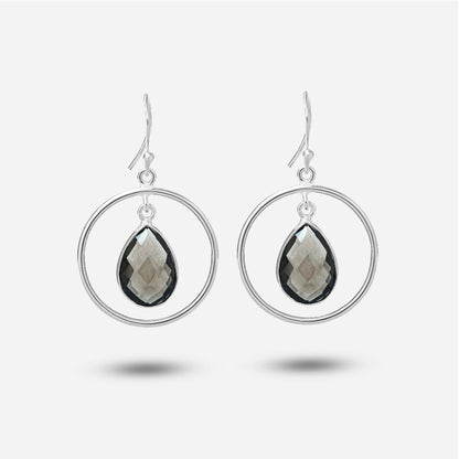 Silver hoop earrings with teardrop-shaped gemstones on a white background
