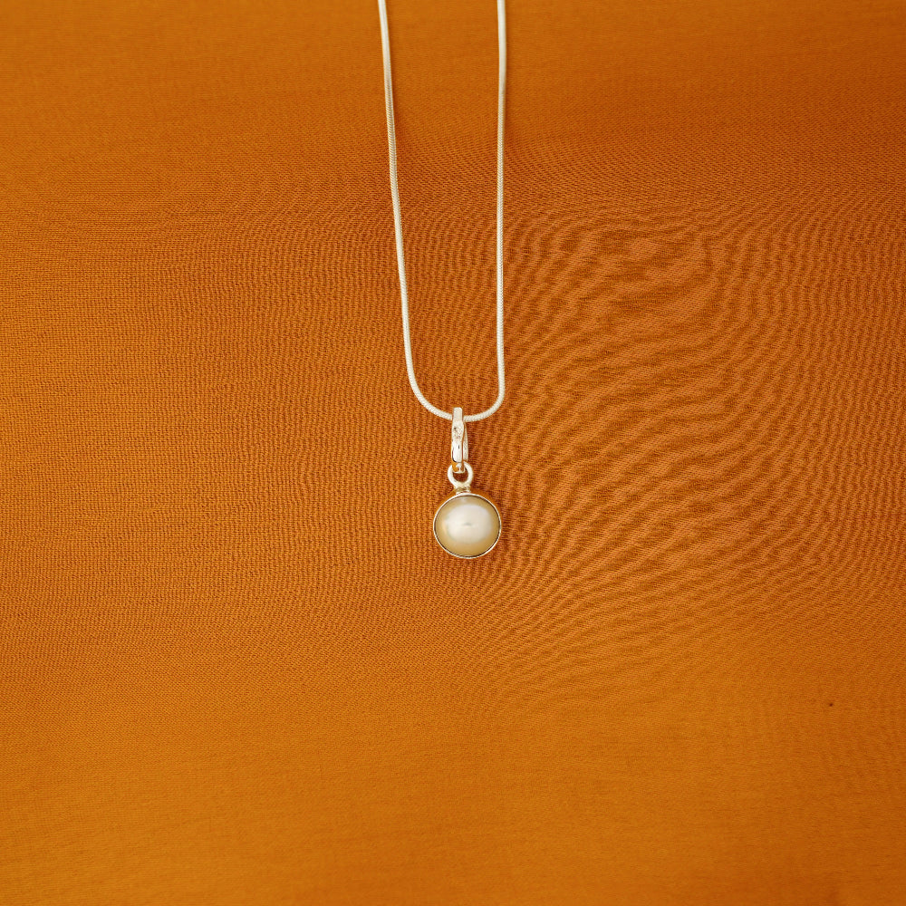 a silver necklace with a pearl pendant by Silver World.