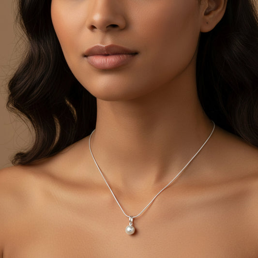 Close-up of a woman wearing a silver necklace with a pearl pendant by Silver World.