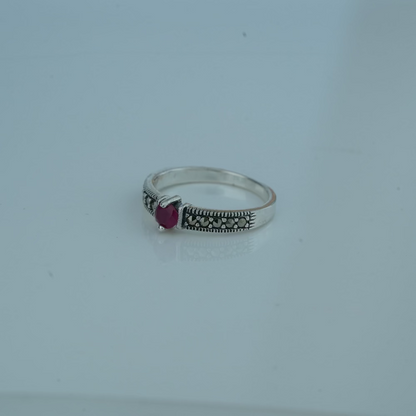 Silver ring with a  gemstone on a light gray background