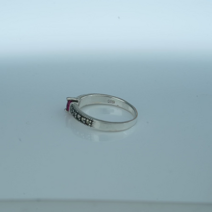 Silver ring with gemstone on a light gray background