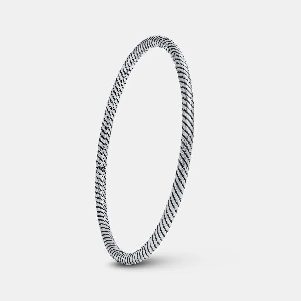 Silver bangle with a striped pattern on a light gray background