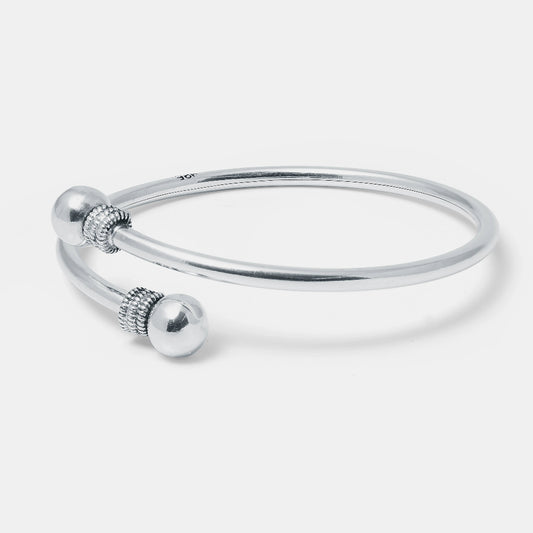 Silver bangle with decorative elements on a light gray background