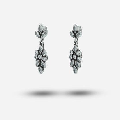 Pair of silver earrings with gemstones on a light gray background