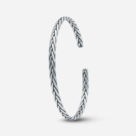 Silver bangle with braided design on a white background