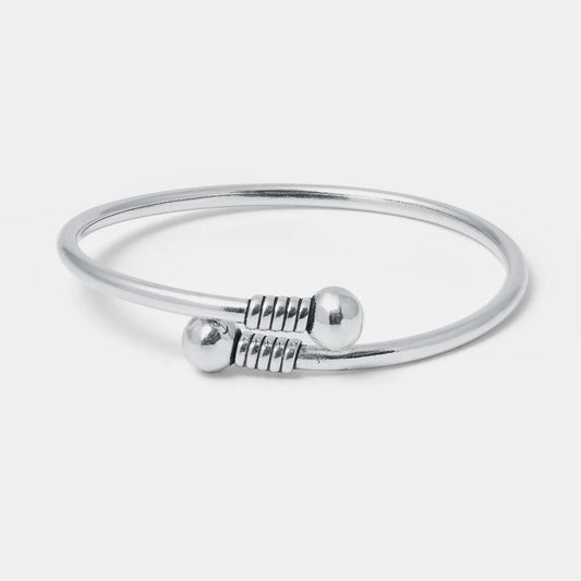 Silver bangle with a clasp on a light gray background