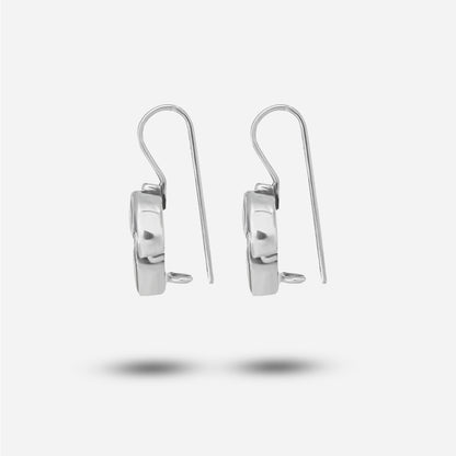 A pair of silver drop earrings on a light gray background