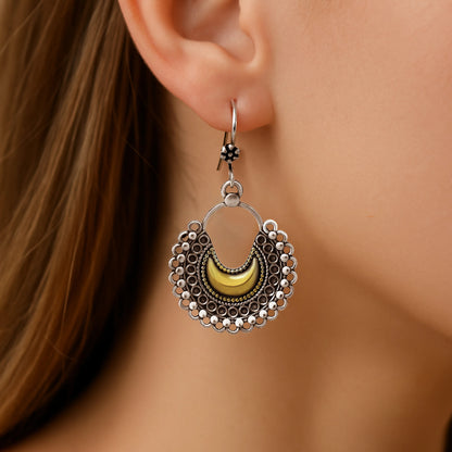 Close-up of a woman wearing a silver half moon earring