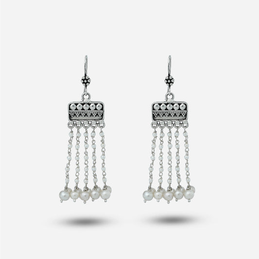 Pair of silver hanging earrings with pearl drops on a white background