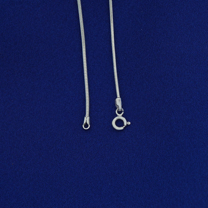 Silver necklace with clasp on a blue background