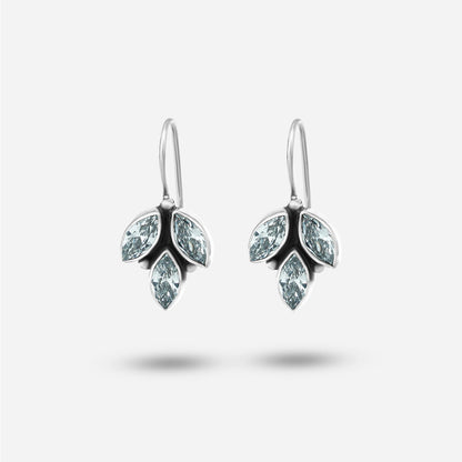 Pair of silver earrings with clear gemstones on a light gray background