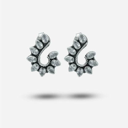 Pair of silver traditional earrings with clear gemstones on a white background