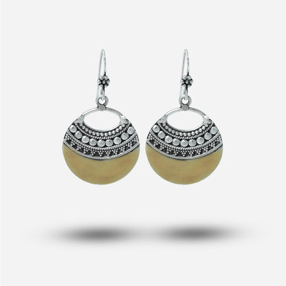 Pair of vintage earrings with silver and beige design on a white background